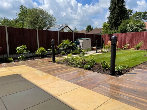 Contrasting paving, planted borders and a family lawn with a timber garden shed.