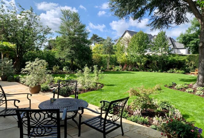 Landscaped garden patio with outdoor dining area and curved lawn