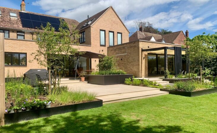 Contemporary landscaped rear garden with patio, raised planting and timber pergola by Deep Rooted